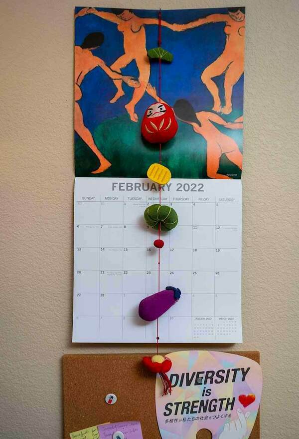 A wall calendar and a tack board on a wall.