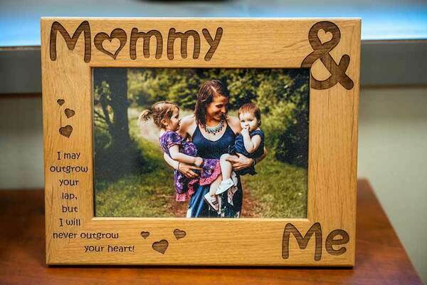 A family frame with a mother holding her two young children.